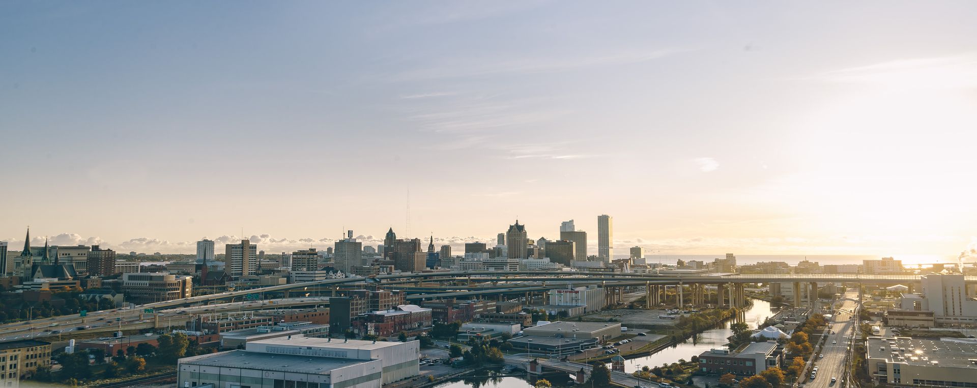 Photograph of the Milwaukee skyline silhouetted by sunlight.