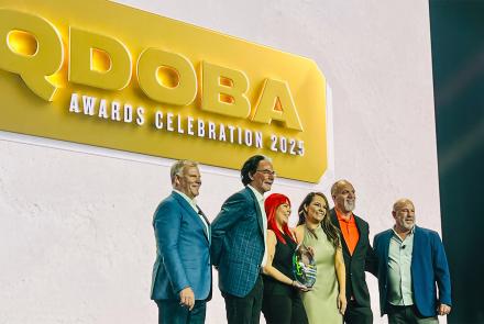 oaring Fork Restaurant Group team accepting awards on stage at the 2025 QDOBA Brand Conference in Scottsdale, Arizona, under the gold QDOBA Awards Celebration 2025 sign.